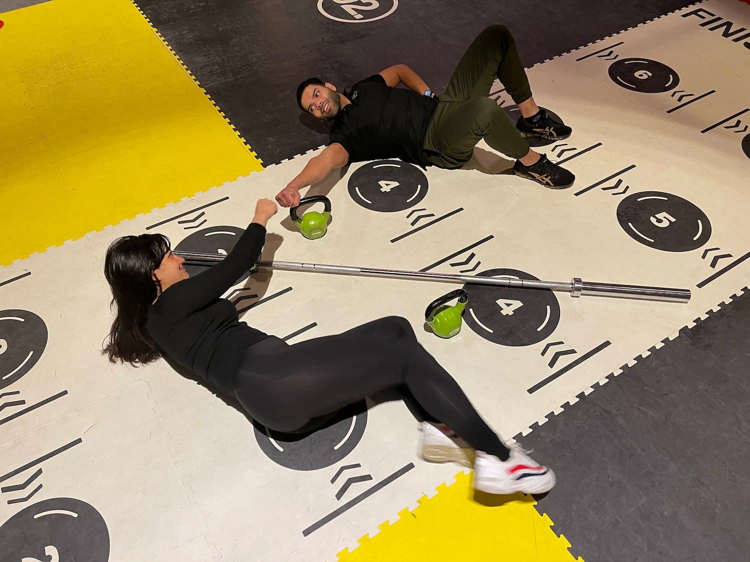 Twee klanten trainen samen met kettlebells